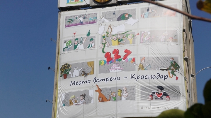 В Краснодаре на «здании с часами» появился забавный баннер с карикатурами из жизни горожан
