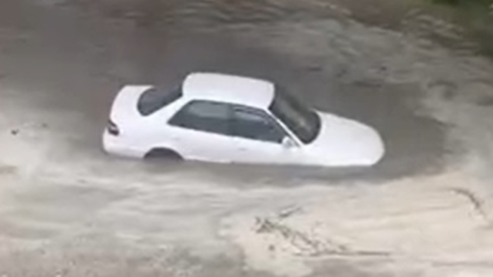После ливня в Новосибирске водитель утопил иномарку в огромной луже