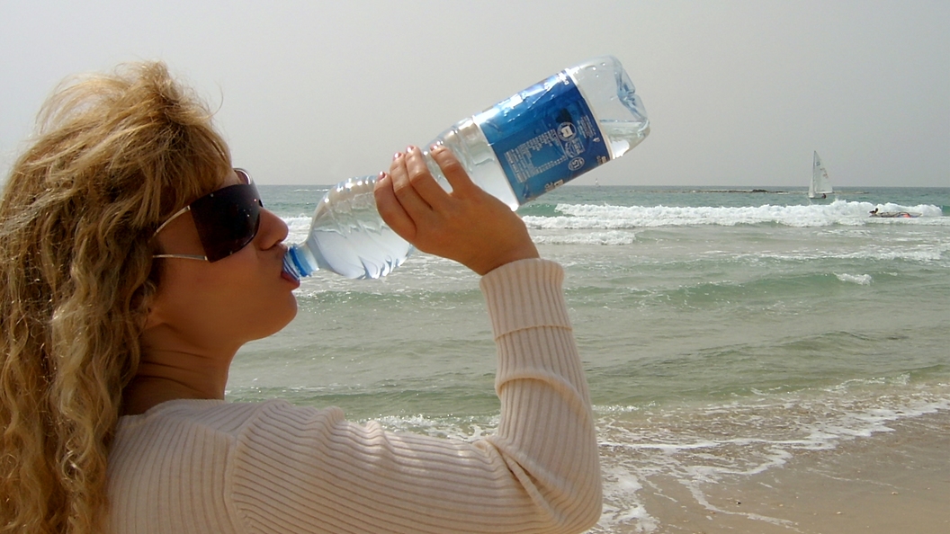 Реализованная вода. Обезвоживание. Предлагает воду. Девушка продает воду. Вода бутилированная в Абхазии.