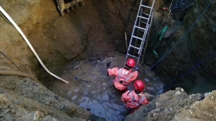 Находящийся под завалами в котловане рабочий рискует утонуть в грунтовых водах