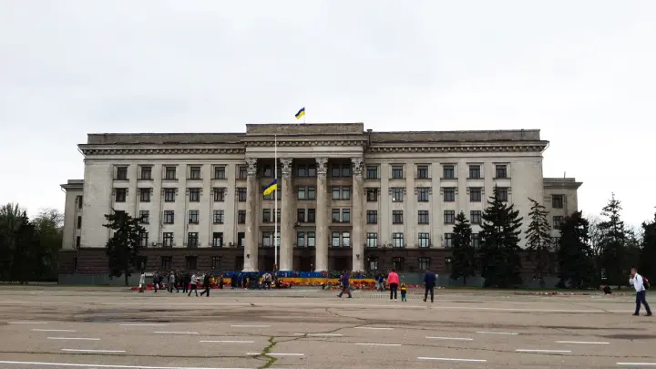 Жители Одессы несут цветы к Дому профсоюзов, несмотря на оцепление площади