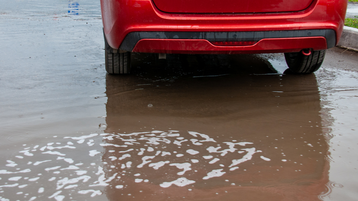 Автомобиль почти полностью провалился в дыру на парковке в Барнауле